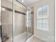 Modern bathroom featuring a glass-enclosed shower with decorative tile accents and a bright window at 2638 Double Oaks Rd, Charlotte, NC 28206