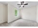 Carpeted bedroom with neutral walls, ceiling fan, and a bright window view at 2638 Double Oaks Rd, Charlotte, NC 28206
