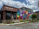 The building's vibrant exterior features a colorful mural and brick facade, blending art with urban architecture at 2638 Double Oaks Rd, Charlotte, NC 28206