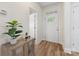 Bright foyer with wood flooring, a decorative table with plant, and a door with decorative glass panels at 2638 Double Oaks Rd, Charlotte, NC 28206