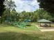 The outdoor playground is surrounded by lush greenery, offering a perfect spot for Gathering fun and picnics at 2638 Double Oaks Rd, Charlotte, NC 28206