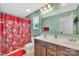 Bright bathroom with double vanity, patterned red shower curtain, and tile floors at 3578 Saddlebrook Dr, Midland, NC 28107
