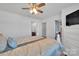 Bright bedroom features a ceiling fan, dresser, and ensuite bathroom and walk-in closet at 3578 Saddlebrook Dr, Midland, NC 28107