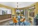 Dining area with a glass table set for four, adjacent to the kitchen and looking out to the backyard at 3578 Saddlebrook Dr, Midland, NC 28107