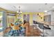 Bright dining area features a glass table, four yellow chairs, and views into the kitchen and hallway at 3578 Saddlebrook Dr, Midland, NC 28107