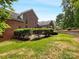 The backyard of this brick home features lush grass and landscaping, and a stone patio at 3904 Hounslow Ln, Harrisburg, NC 28075