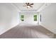 Large bedroom with neutral carpet, tray ceiling, ceiling fan and great natural light at 3904 Hounslow Ln, Harrisburg, NC 28075