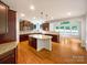 Open kitchen with granite countertops, a large island, stainless steel appliances, and hardwood floors at 3904 Hounslow Ln, Harrisburg, NC 28075
