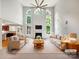 Bright, staged living room with tall ceilings, a ceiling fan, a fireplace and large windows with natural light at 3904 Hounslow Ln, Harrisburg, NC 28075