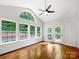 Cozy sunroom with hardwood floors, bright windows, vaulted ceilings, and a ceiling fan at 3904 Hounslow Ln, Harrisburg, NC 28075