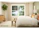 Well-lit bedroom with a large window, neutral color scheme, wooden furniture and decor, and views of the outdoors at 3915 Horsham St, Indian Land, SC 29707