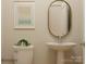 Compact half bathroom featuring a pedestal sink, modern art, and neutral wall color at 3915 Horsham St, Indian Land, SC 29707