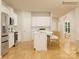 Modern kitchen with stainless steel appliances, white cabinets, an island with seating, and wood flooring at 3915 Horsham St, Indian Land, SC 29707