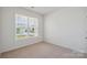 Bright bedroom featuring neutral carpet, a large window, and ample natural light at 4527 Dover Ct, Denver, NC 28037