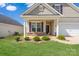Inviting home exterior features stone accents, a covered porch and manicured landscaping at 4527 Dover Ct, Denver, NC 28037