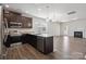 A kitchen with stainless steel appliances, dark cabinets, granite countertops, and an open living area at 4527 Dover Ct, Denver, NC 28037