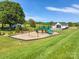 Community playground featuring swings, slides, and a green lawn with pool house at 4527 Dover Ct, Denver, NC 28037
