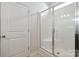 All-white shower featuring glass doors and a corner bench, offering a clean and modern bathroom experience at 4527 Dover Ct, Denver, NC 28037