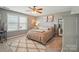 Neutral toned bedroom with a decorative area rug, window view, and ceiling fan at 475 Hunton Forest Nw Dr, Concord, NC 28027