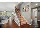 Inviting home foyer with wood floors, staircase, and decorative Gathering wall art at 475 Hunton Forest Nw Dr, Concord, NC 28027