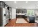 Open-concept kitchen with stainless steel appliances, granite countertops and dark wood floors, ideal for entertaining at 475 Hunton Forest Nw Dr, Concord, NC 28027