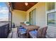 Covered back porch with a wooden table, chairs, and ceiling fan, perfect for outdoor dining and relaxation at 475 Hunton Forest Nw Dr, Concord, NC 28027