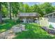Charming backyard featuring a stone fire pit, lush lawn, and a quaint stone patio, perfect for outdoor gatherings at 4960 Longfield St, Claremont, NC 28610