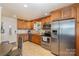 Well-lit kitchen with stainless steel appliances, wooden cabinets, tile flooring, and granite countertops at 4960 Longfield St, Claremont, NC 28610