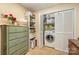 Well-organized laundry room with a washer inside a closet, storage shelves and green painted dresser for convenience at 4960 Longfield St, Claremont, NC 28610