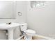 Cozy half-bathroom featuring modern pedestal sink and toilet at 526 N Davidson St, Charlotte, NC 28202
