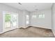 Sunlit bedroom featuring carpeting and sliding doors to a small balcony at 526 N Davidson St, Charlotte, NC 28202