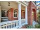 Inviting covered front porch with classic white columns and railing, leading to the brick-accented entryway of the home at 526 N Davidson St, Charlotte, NC 28202