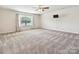 Large bedroom with a ceiling fan, mounted TV, and lots of space for furniture arrangement at 5355 Hackberry Sw Ln, Concord, NC 28027