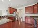 Kitchen features stainless steel appliances, cherry cabinets, and hardwood floors at 5355 Hackberry Sw Ln, Concord, NC 28027