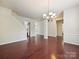 Open living room with hardwood floors, wainscoting, and modern chandelier at 5355 Hackberry Sw Ln, Concord, NC 28027