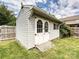 Backyard storage shed featuring white wood construction, double doors, and ramp at 5355 Hackberry Sw Ln, Concord, NC 28027