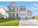 Charming two-story home with a manicured lawn, two-car garage, stone accents and inviting covered front porch at 5594-C Galloway Dr # 99P, Stanfield, NC 28163