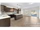 Open-concept kitchen and dining area with dark cabinets, stainless steel appliances, an island, and a sliding door to the backyard at 5634-A Galloway Dr # 96P, Stanfield, NC 28163