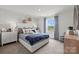Bright bedroom featuring patterned wallpaper, plush bedding, and natural light from a window with blue drapes at 566 Mountain View Dr, Monroe, NC 28110