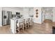 Stylish kitchen island with seating, white cabinets, and stainless steel appliances at 566 Mountain View Dr # 220, Monroe, NC 28110