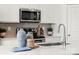 Modern kitchen featuring stainless steel appliances, white cabinetry, and elegant countertops with decorative items at 566 Mountain View Dr # 220, Monroe, NC 28110