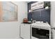 Functional laundry room with modern washer, dryer, shelving, and stylish decor at 566 Mountain View Dr, Monroe, NC 28110