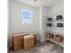 Well-organized laundry room with wire shelving, wicker baskets, and a window providing natural light at 566 Mountain View Dr, Monroe, NC 28110