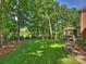 Expansive backyard featuring lush lawn, mature trees, and a screened porch perfect for outdoor living at 5917 Summerston Pl, Charlotte, NC 28277