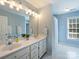 Bright bathroom featuring a double vanity, a large mirror, and a walk in shower with tiled flooring at 5917 Summerston Pl, Charlotte, NC 28277