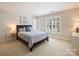 Comfortable bedroom featuring a queen bed, neutral walls, and bright window with shutters at 5917 Summerston Pl, Charlotte, NC 28277