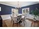 Bright dining room featuring crown molding, a modern chandelier, and large windows with views of the outdoors at 5917 Summerston Pl, Charlotte, NC 28277