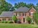 Beautiful two-story brick home with manicured lawn and mature trees in a well-maintained community at 5917 Summerston Pl, Charlotte, NC 28277