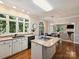 Bright kitchen features an island cooktop, granite countertops, and views of trees outside the window at 5917 Summerston Pl, Charlotte, NC 28277