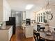 Well-lit kitchen features an island, black appliances, white cabinets, and hardwood floors at 5917 Summerston Pl, Charlotte, NC 28277